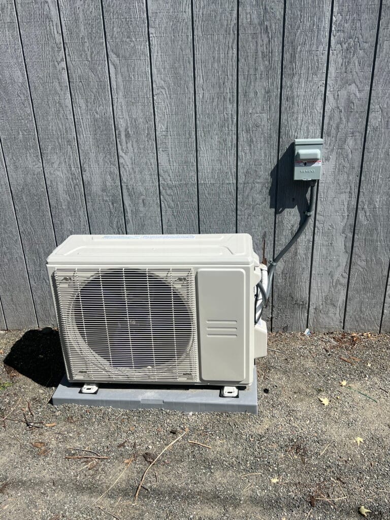 Outdoor cooling system condenser installed next to a fence