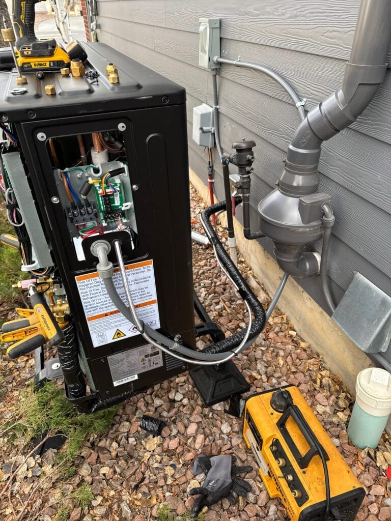 Heat pump rebate eligible outdoor unit installation with refrigerant lines and electrical connections
