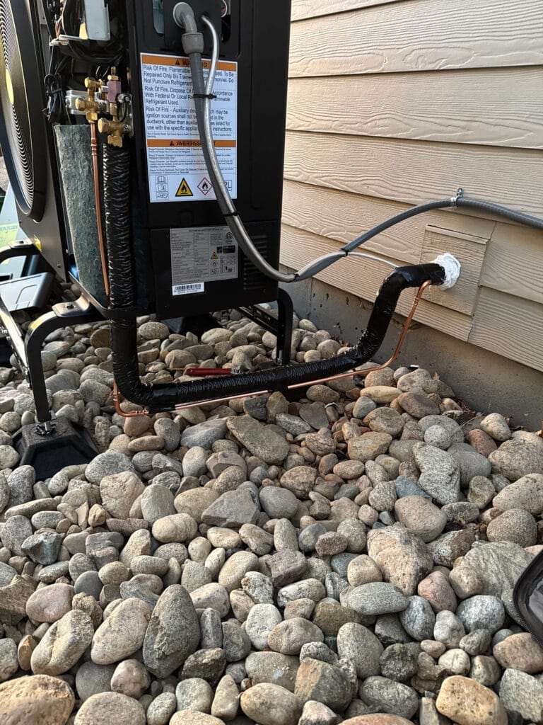 Cooling system line set and refrigerant piping connected beside a home