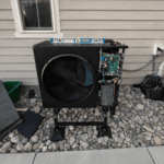 Outdoor heat pump installation denver using unit with service panel open during HVAC inspection in Denver Metro