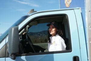 Female HVAC technician in a Denver metro service truck, hvac coupon in tow