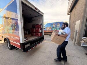 HVAC technician carrying air filters from service truck during A/C repair visit
